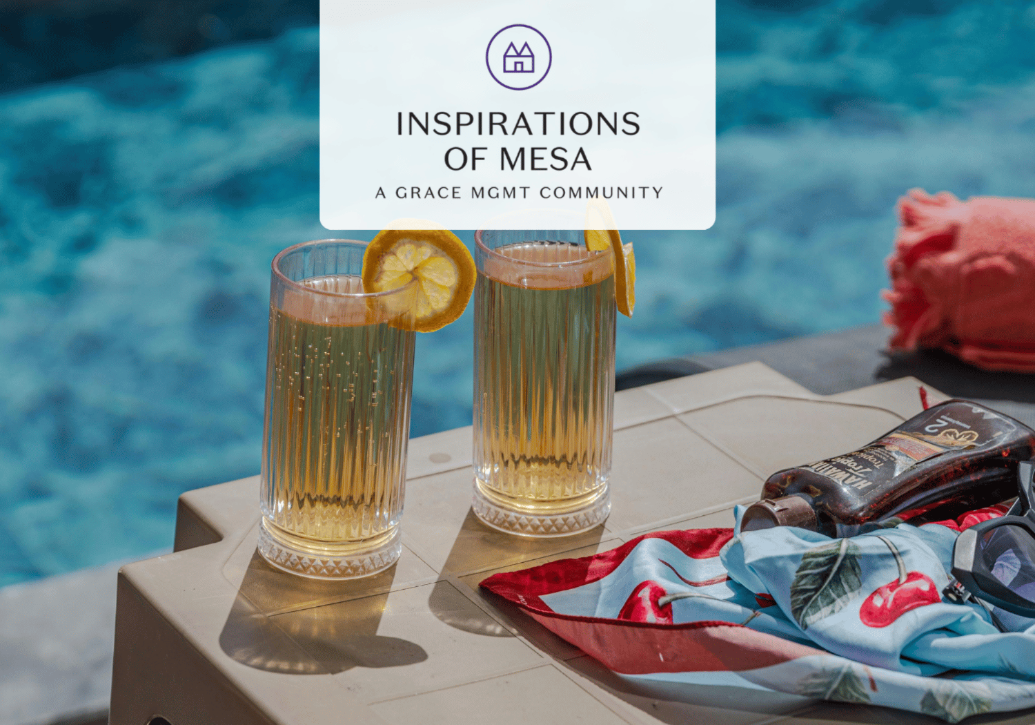 Poolside scene with two tall, citrusy drinks garnished with lemon slices on a beige table by a blue pool edge; summery vibe for Inspirations of Mesa.